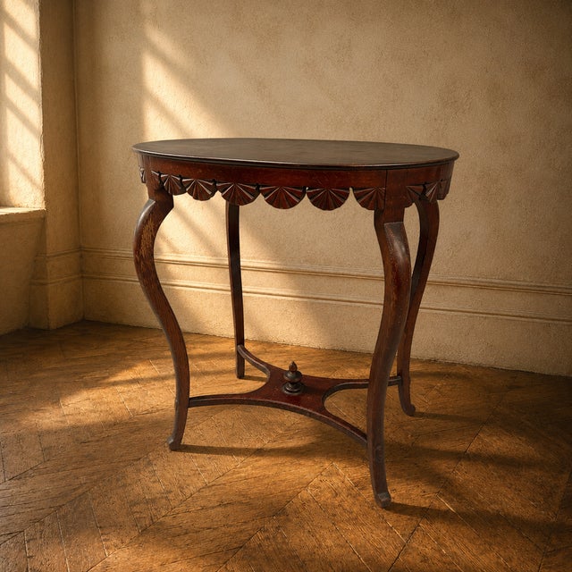 A distinctive Art Nouveau side table crafted from solid wood, with gracefully curved legs, a decorative carved apron with...