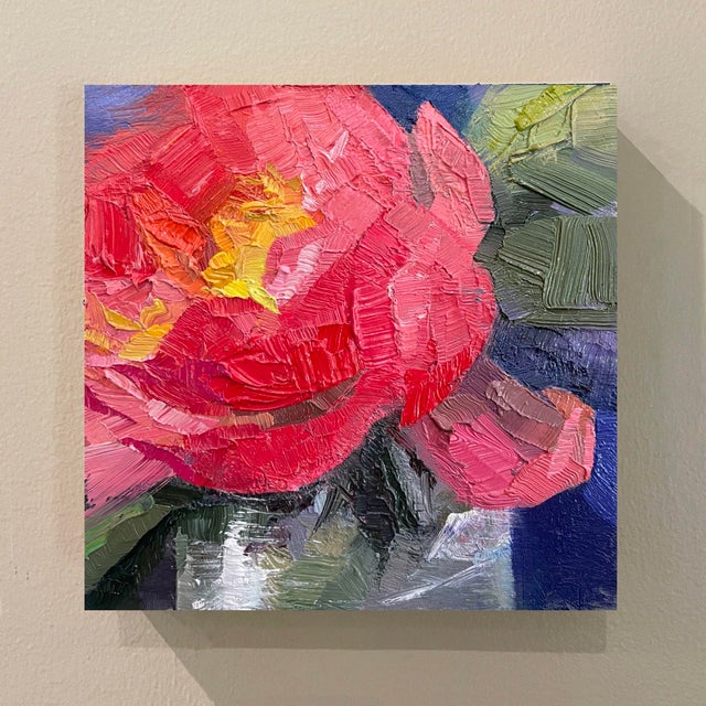This oil on board piece captures the vibrant hues of a peony in full bloom, showcasing a rich palette of reds and pinks....