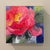 This oil on board piece captures the vibrant hues of a peony in full bloom, showcasing a rich palette of reds and pinks....