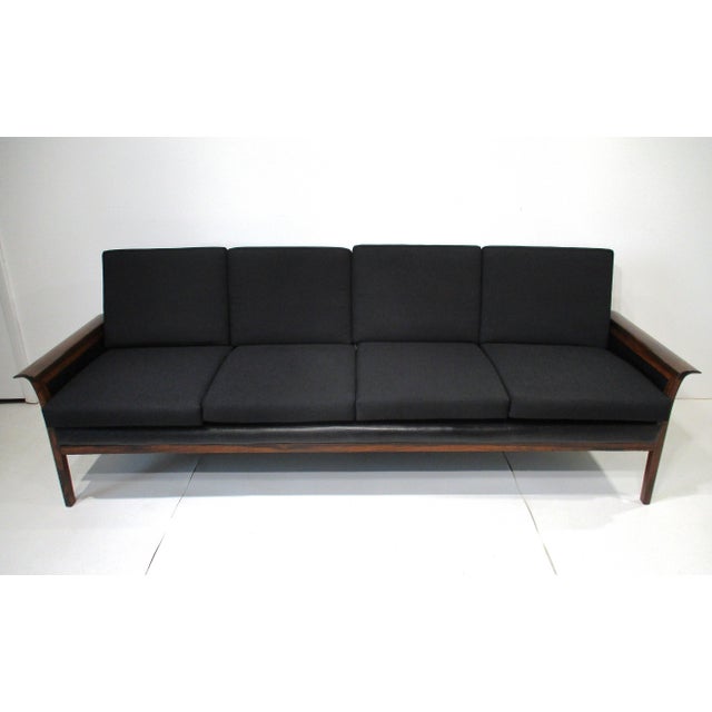 A stunning Brazilian rosewood framed four cushion sofa with black woven fabric cushions and leather back. The sofa has...
