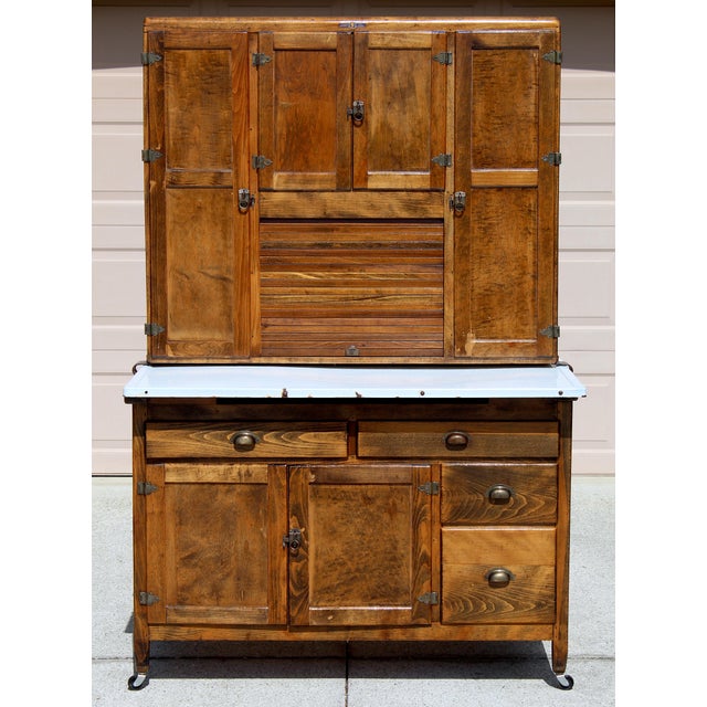 A beautifully preserved early 20th-century Hoosier-style kitchen cabinet, crafted from solid wood and rich with authentic...