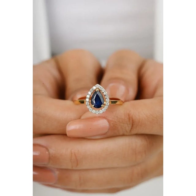 This is part of Chairish’s Fine Jewelry assortment. Pear Blue Sapphire Round Diamond Halo Engagement Ring in 18K Gold...