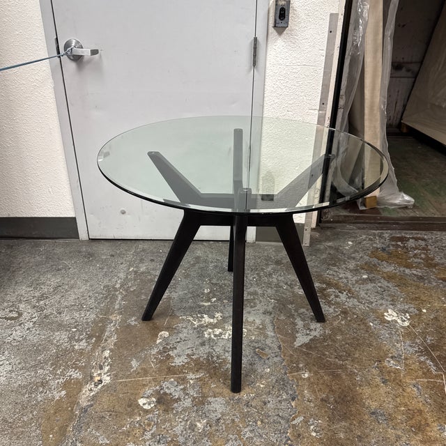 Design Plus Gallery presents the Jensen Round Dining Table from West Elm. A circular glass top reveals an architectural...