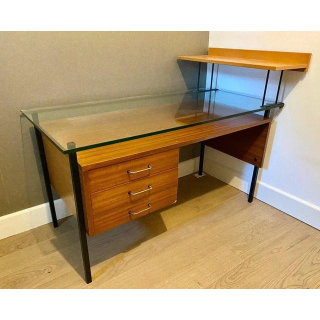 "50's modernist desk" 50's modernist desk in mahogany veneer 3 drawers 10mm thick glass top. This piece is attributed to...