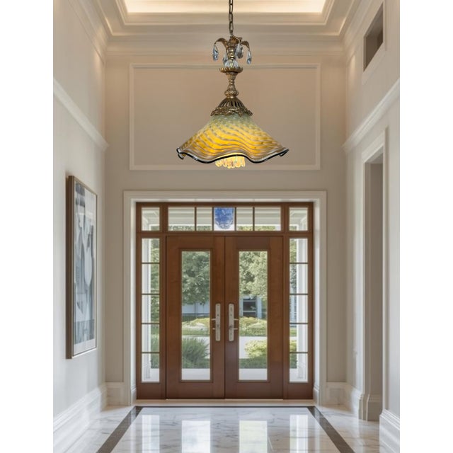 This one‑of‑a‑kind pendant light is a striking fusion of antique craftsmanship and contemporary hand‑blown artistry. Its...