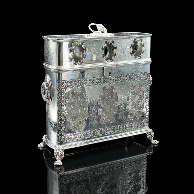 This is an antique tantalus. An English, silver plated three decanter set dating to the Edwardian period, circa 1910. A...