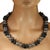 This 24‑inch black and silver necklace has a bold, sculptural presence that makes it an instant statement piece. The...