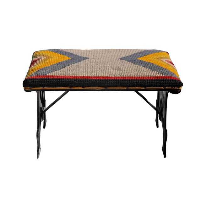 Vintage accent bench features an eye-catching woven Kilim rug upholstered top paired with a distinctive black cast iron base.