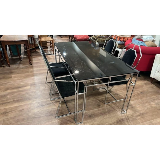 This vintage chrome dining table set features a sleek rectangular chrome frame, a clear plexiglass top, and four high-back...