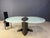 Striking postmodern design dining table consisting of a brushed aluminuml base with two matte glass table tops and a brass...
