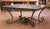 Bring authentic vineyard character into your home with this striking French iron and oak dining table, crafted circa 1970...