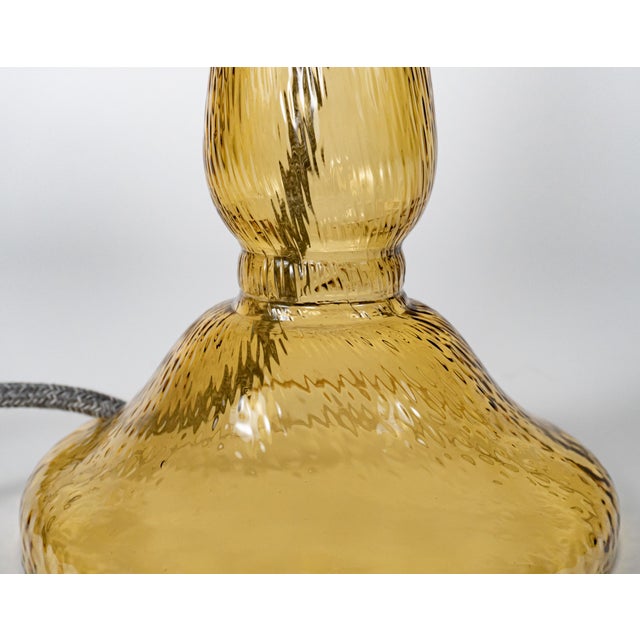 An unusual vintage triform glass table lamp made of clear glass with random straps of vibrant red, cased again in clear,...