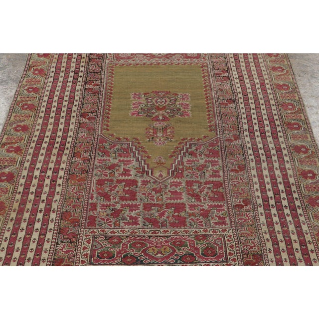 Hand-knotted in wool, this 4x7 Vintage Turkish Anatolian Prayer Rug, circa 1950–1959, features an elegant olive-green...
