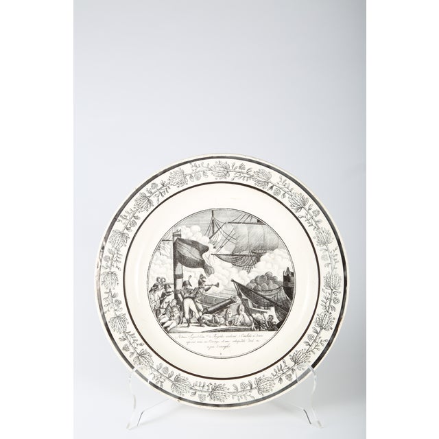 Set of two French faience plates featuring black transfer-printed designs with Napoleonic imagery. Marked "P&H Choisy" on...