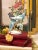 This vintage Royal Sealy porcelain figurine features a vibrant, hand-painted tropical parrot perched elegantly on a...