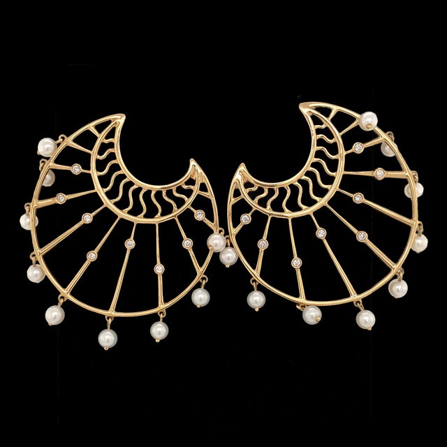 A fun pair of large, pierced post earrings in 14K yellow gold. The earrings are fan shaped with openwork rays with bezel...