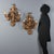 A pair of perforated and carved wooden wall lamps featuring an elaborate design of leaves and swirls. The lacquered and...