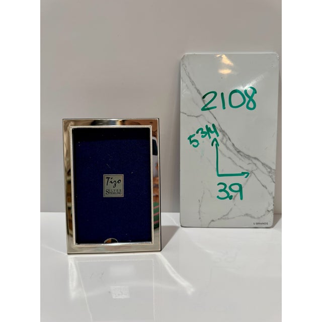 Small Tigo sterling silver picture frame with polished silver border, beaded inner edge, and blue velvet backing. Marked...