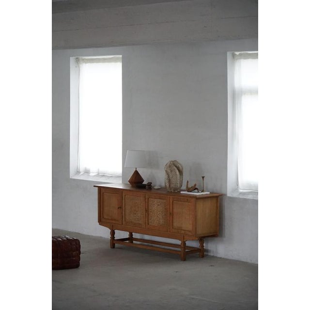 A sculptural low rectangular classic sideboard / cabinet in oak with plenty of storage and a beautiful carved front...
