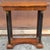 A Patinated 19th Century Biedermeier Single Drawer Console Table featuring a walnut grain top, ebonized Doric columns with...