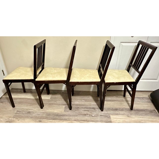 Set of 4 vintage Leg-O-Matic folding chairs. Dark wood stain with neutral creamy/ivory colored vinyl seats. Each chair...