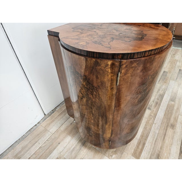An elegant 1940s Art Deco sideboard, crafted from walnut and embellished with a refined walnut crotch veneer, featuring...