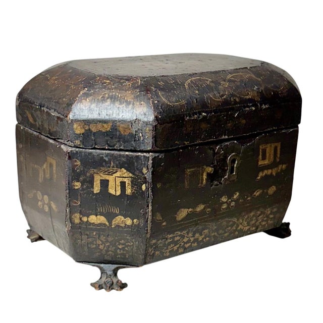 An early 19th century Chinese export black lacquer tea caddy, richly decorated with hand painted gilt scenes depicting...