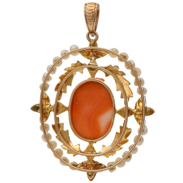 This carved cameo and seed-pearl-outlined Victorian pendant fashioned from intricately worked 10K yellow gold will turn...