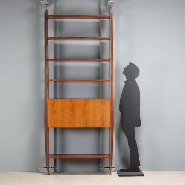 Vintage 1950s-60s bookcase with floor-to-ceiling anchoring structure, featuring open shelves offering ample space for...