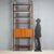 Vintage 1950s-60s bookcase with floor-to-ceiling anchoring structure, featuring open shelves offering ample space for...