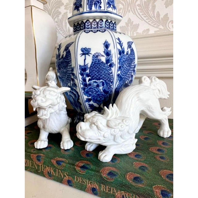 A graceful pair of white porcelain Foo Dogs, also known as Chinese guardian lions — timeless symbols of protection,...
