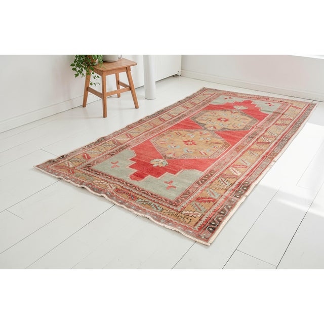 This is a vintage Turkish Oushak rug from the Mid 20th Century. The piece was hand-knotted.