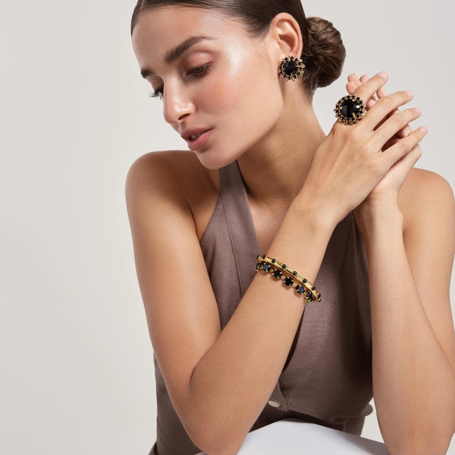 A stunning fusion of Art Deco elegance and metropolitan flair, the Isabella Studs feature a bold round centerpiece framed...