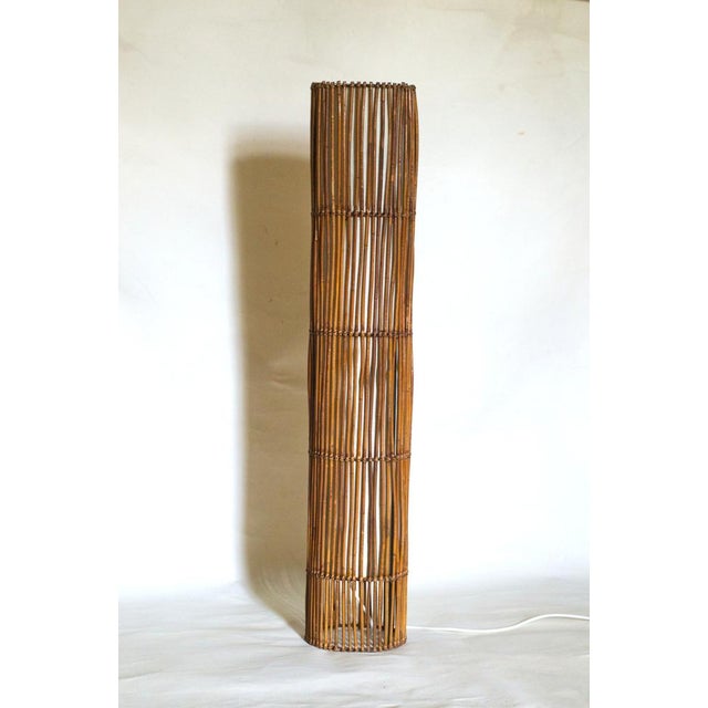 Elegant and highly decorative rattan floor lamp, designed in the 1960s. Made with a metal frame, rattan canes, and cotton...