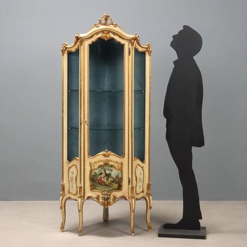 Lacquered and painted corner display cabinet in Late Baroque style. Central glass door surmounts a painted panel depicting...