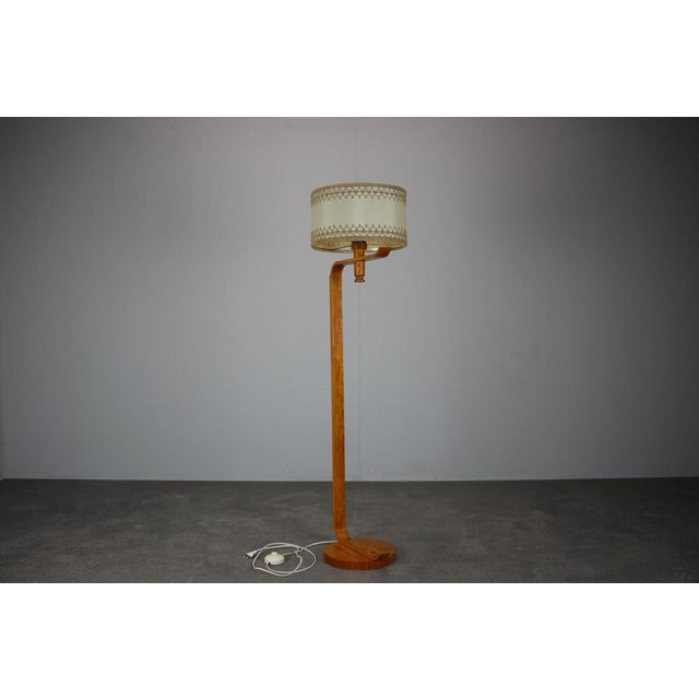 A refined Mid Century wooden floor lamp produced in Europe during the 1960s. The lamp features a sculptural bentwood...