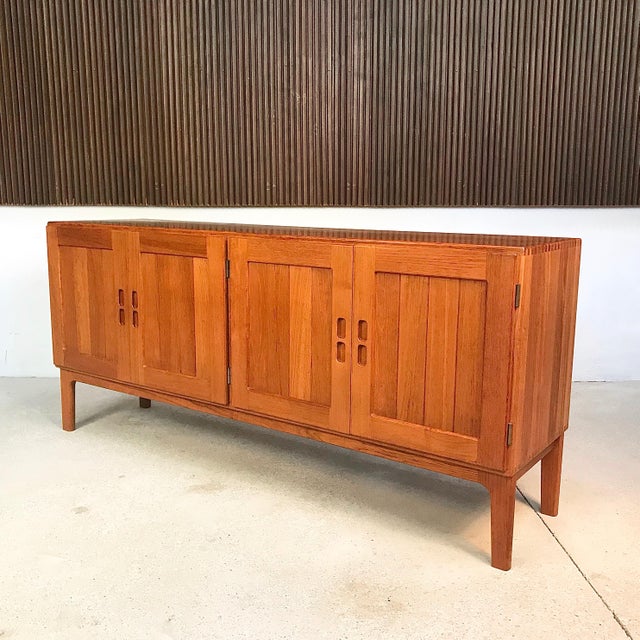 This high-quality sideboard is made from solid teak and was manufactured in Denmark during the 1960s. It is stamped on the...