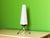 Atomic Age tripod table lamp is an example of mid-century modernism. The shade is made of striped frosted glass, and the...