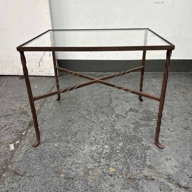 Design Plus Gallery presents a Glass + Iron Side Table. The simple table has subtle hints of craftsmanship on the hammered...