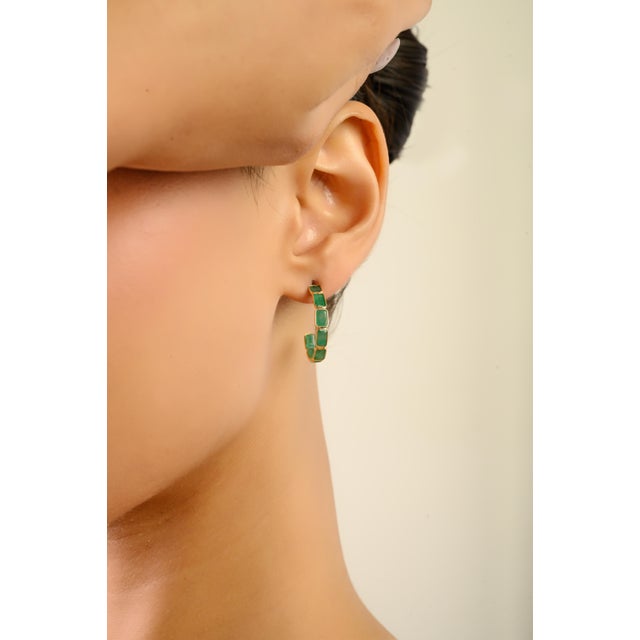 These elegant hoop earrings feature 16 octagon-cut emeralds totaling 5.45 carats, set in 18K yellow gold. Each gemstone...