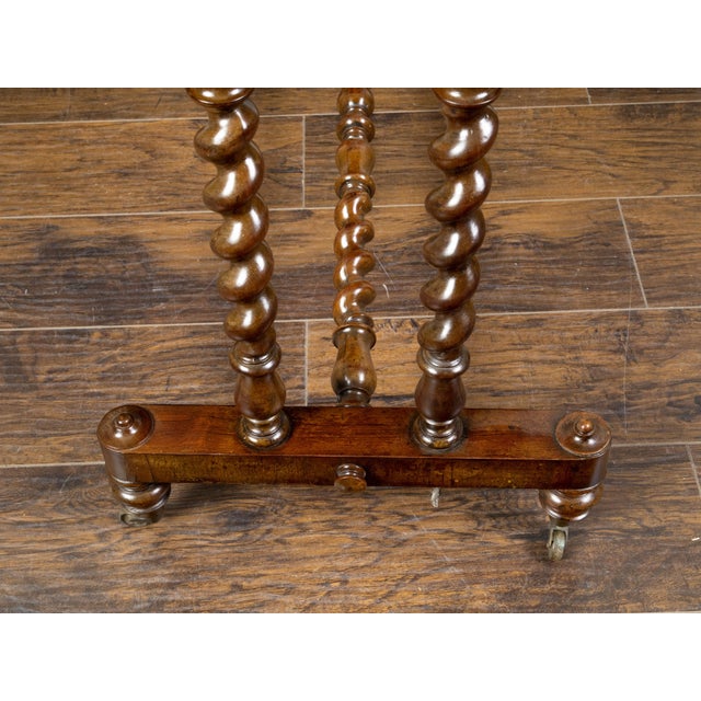 An English mahogany table from the mid 19th century, with barley twist base and casters. Created in England during the...