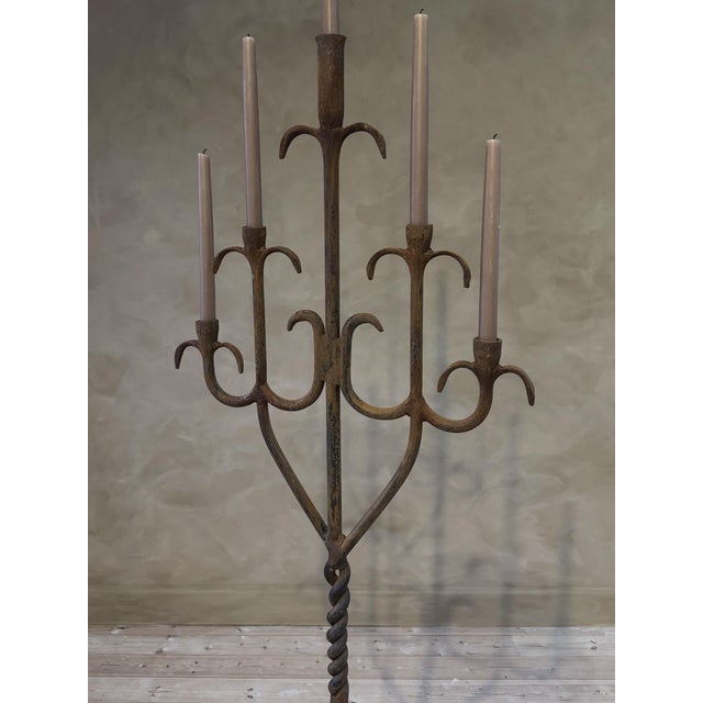 Our 20th century wrought iron candelabra stands just under 6ft tall.Dramatic and atmospheric, it rises from a quatreform...