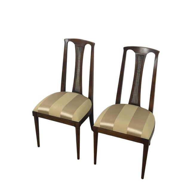 A distinctive pair of vintage mid-century modern dining chairs featuring exceptionally tall sculpted wood backs, narrow...