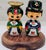 Vintage hand-painted Japanese kokeshi-inspired wooden couple dolls displayed on a carved wood base, perfect for adding a...