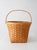 A vintage splint weave basket featuring a bentwood bail handle and a warm honey-toned finish. The gently tapered square...