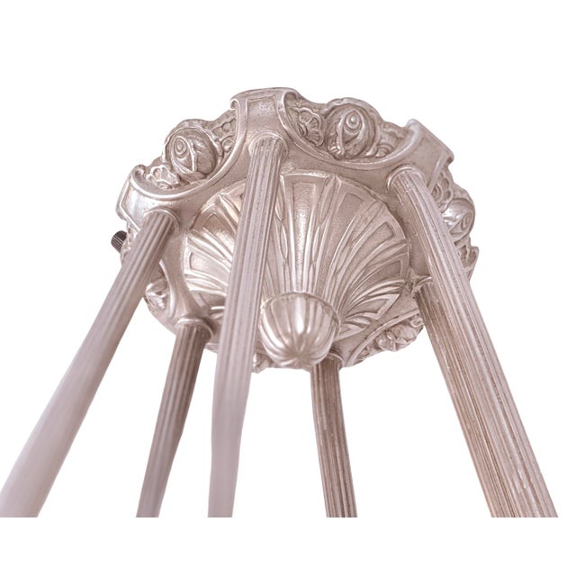 A 1930s French Art Deco chandelier by *Verrerie des Hanots*, featuring clear frosted glass and finely detailed metalwork....