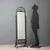 Wrought iron psyche. Tilting mirror supported by two square columns resting on curved feet with curled workmanship. Italy,...