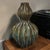 This vintage glazed pottery double gourd ribbed vase features a unique design in earth tone colors, typical of Mid-Century...