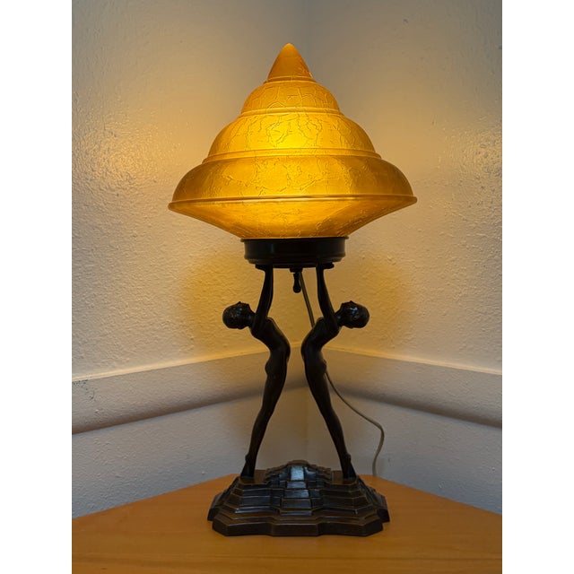 Nuart double nude figure lamp with frosted glass spiral lampshade and bronze finish. Lamp has been re-wired and is in...