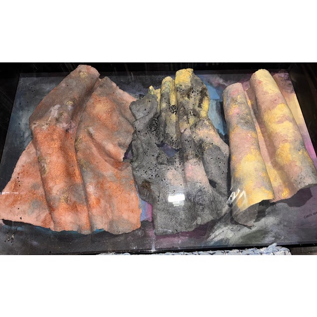 One-of-a-kind mixed media wall art featuring layered, stone-like textural elements arranged in a bold horizontal...
